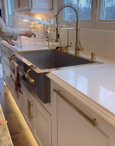 a woman is standing in front of a kitchen sink