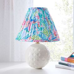 a lamp that is on top of a table next to books and a bookcase