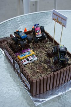 a birthday cake with monster trucks on it