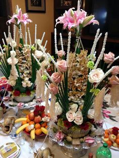 there are many flowers and fruits on the table with food in bowls next to each other