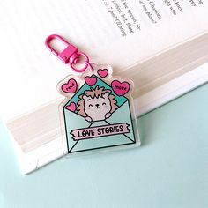 a keychain with a sticker on it that says love stories in pink