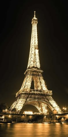 the eiffel tower lit up at night with lights on it's sides