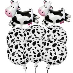 three inflatable cow balloons are sitting on top of each other, one is black and white