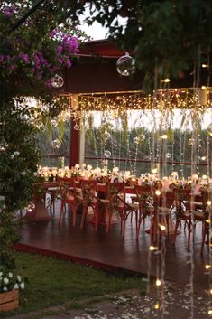 an outdoor dining area with lights strung from the ceiling and tables set up for dinner