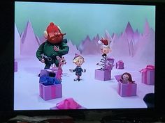 an animated christmas scene is shown on the television screen, with santa's helpers