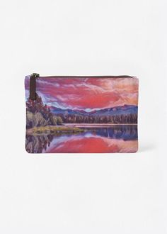 a small purse with a painting on the front and side of it, sitting on a white surface