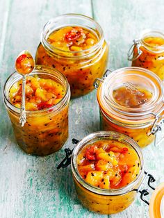 four jars filled with food sitting on top of a table