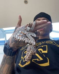 a man holding his hands up to his face with multiple bracelets on each hand