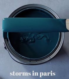 a blue paint can with a wooden handle and the words storm in paris painted on it