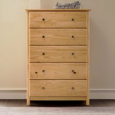 a wooden chest of drawers sitting on top of a hard wood floor next to a wall