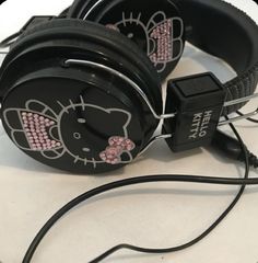 the hello kitty headphones have pink bows on them and are attached to black cords