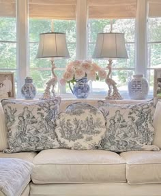 a living room filled with lots of furniture and flowers in vases on the table