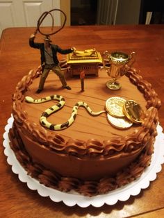 a cake with a snake on it and a man holding a tennis racquet