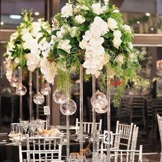 the centerpieces are filled with white flowers and greenery