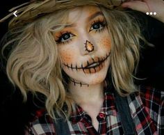 a woman wearing a scarecrow hat with long blonde hair and makeup on her face