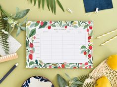 a table topped with plates and plants next to a calendar