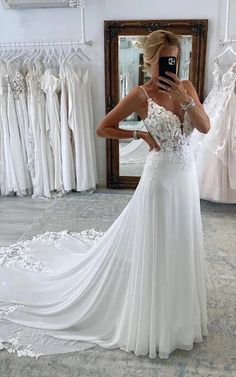 a woman is taking a selfie in front of her wedding dress while looking at her phone