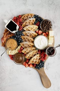 a platter with waffles, fruit, and other toppings on it