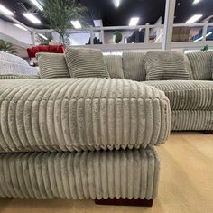 two large couches sitting next to each other on a wooden floor in a store