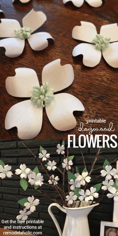 some flowers are sitting in a white vase on a table with pictures and an old photo