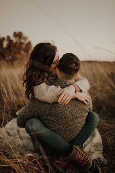 a couple cuddling in the tall grass