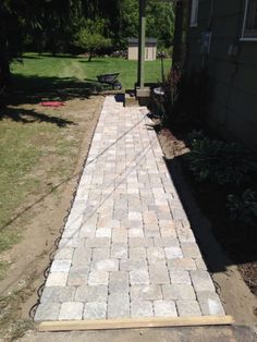 a brick walkway is being built in the yard