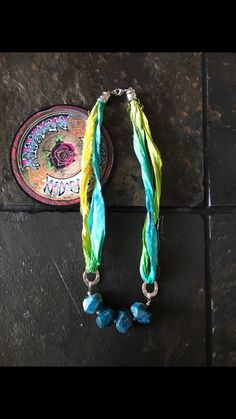 two necklaces are sitting on a tile floor