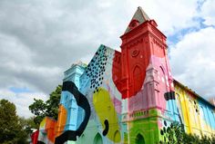 a colorful building with a clock tower on the front and side, painted in bright colors