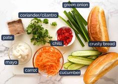 the ingredients for a sandwich laid out on a cutting board, including carrots, celery, cucumber, sour cream and bread