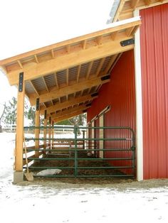 a red barn with a wooden roof and metal railings