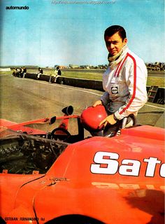 a man sitting on top of an orange race car