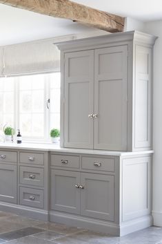 a kitchen with gray cabinets and white walls