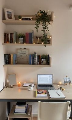 a laptop computer sitting on top of a wooden desk next to a white chair and bookshelf