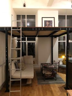 a loft bed with a couch underneath it in a living room next to a window