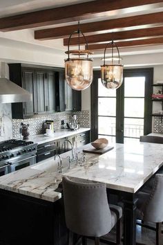 a kitchen with black cabinets and white marble counter tops is featured on the instagram page