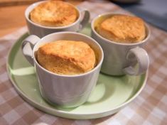 three mug cakes sitting on top of a green plate