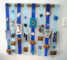 a blue and white striped wall hanging with numbers, stars, and letters on it