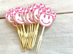 a bunch of wooden sticks with smiley faces cut out of them sitting next to each other