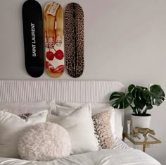 two surfboards mounted to the wall above a bed with pillows and blankets on it