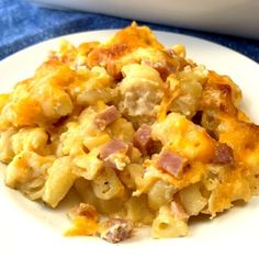 a white plate topped with macaroni and cheese next to a casserole dish