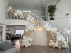 a staircase decorated with white balloons and greenery