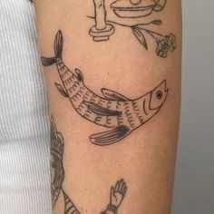 a woman with a tattoo on her arm and some fish in the water next to it