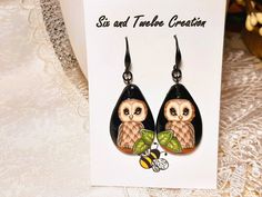 the earrings are decorated with an owl and bee