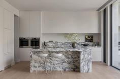 a kitchen with marble counter tops and stools