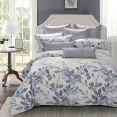 a bed with blue and white comforters in a bedroom next to a window,