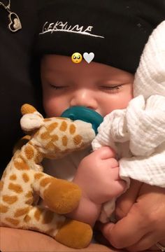 a baby is holding a stuffed giraffe