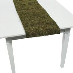 a white table with grass on the edge