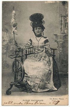 an old photo of a woman sitting on a chair with a wheel in her hand