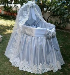 a baby's crib in the grass with a veil over it