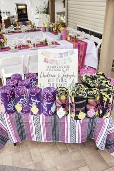 the table is set up with purple and yellow ribbons on it for guests to sit down